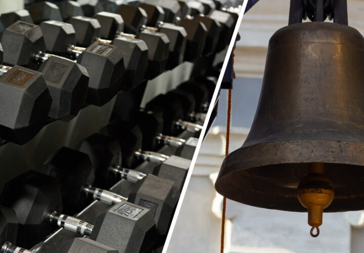 Dumbbells on a gym rack beside a large hanging bell.