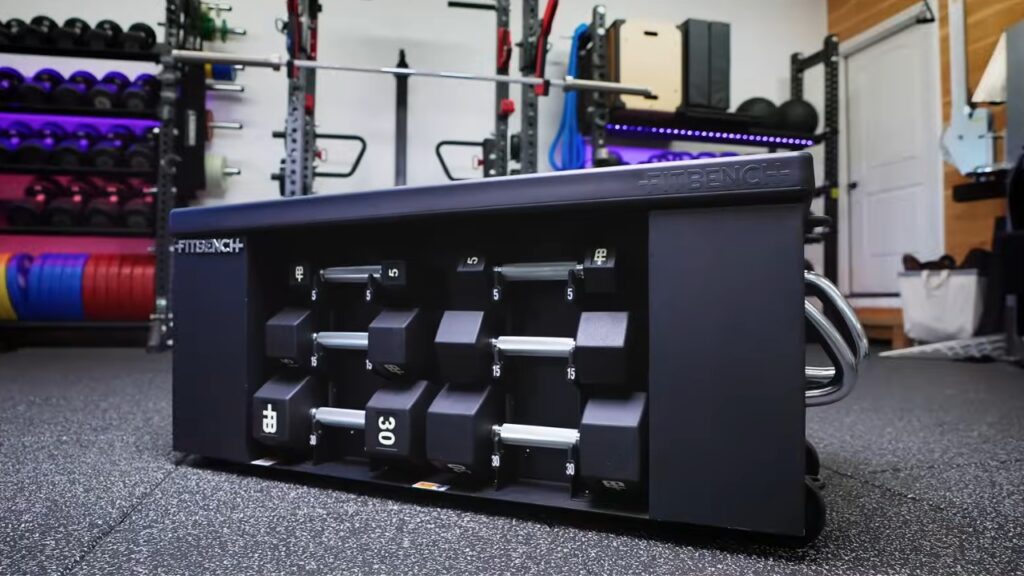 Fold-away bench with dumbbells in a compact garage gym.