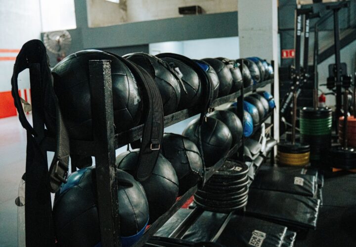 Medicine balls and weight plates stored in a compact garage gym.