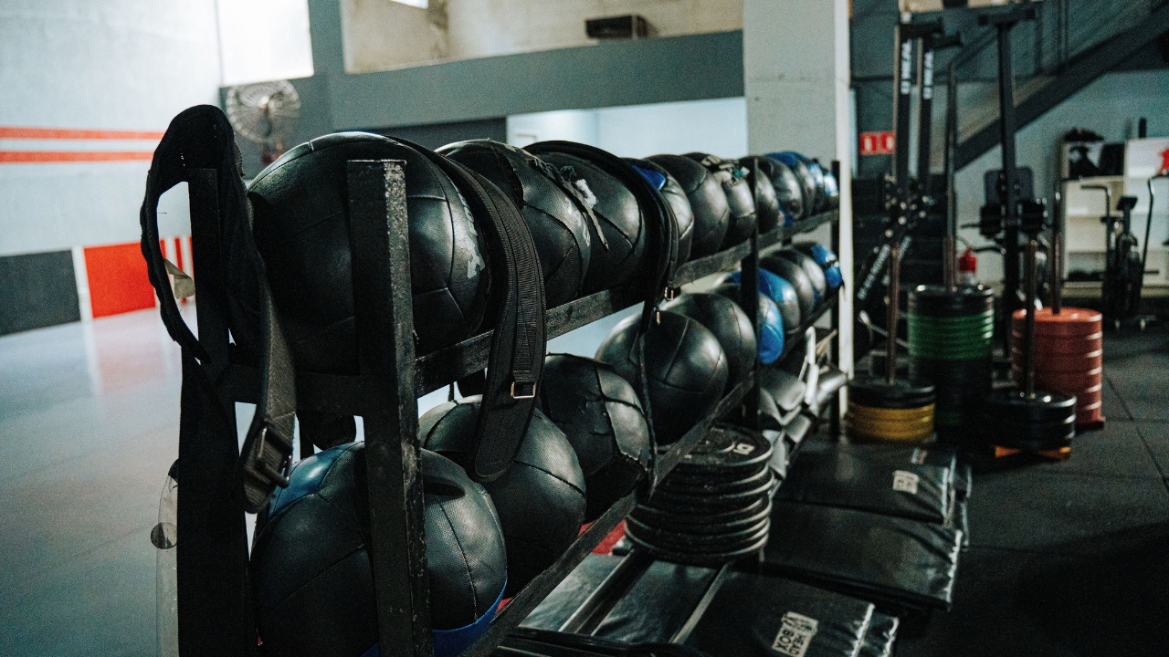Medicine balls and weight plates stored in a compact garage gym.