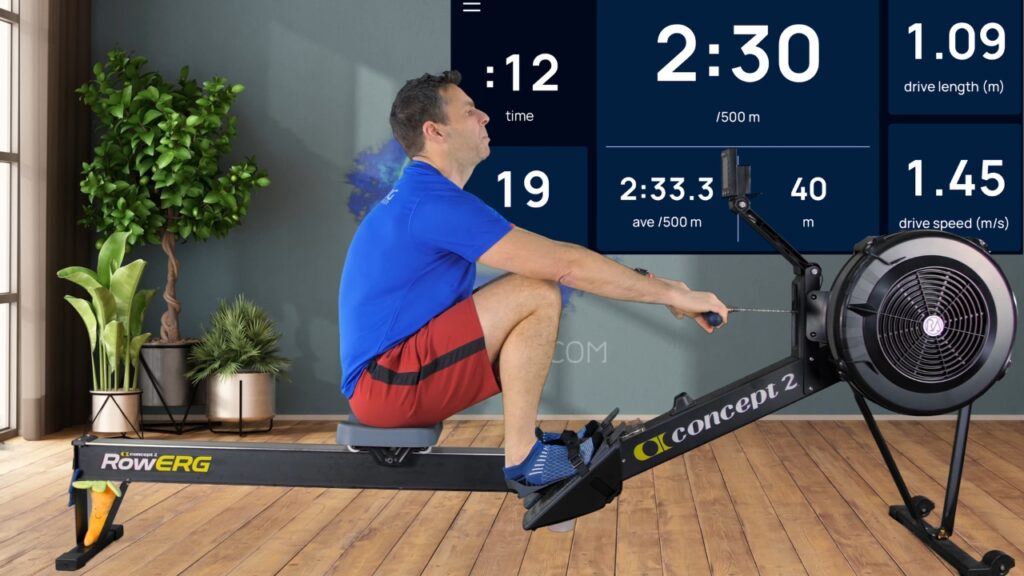 A man uses a Concept2 RowErg as a screen displays his pace and stroke data.