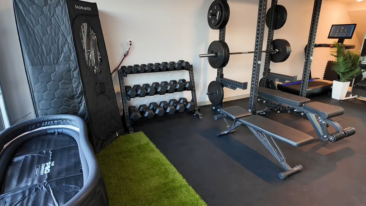 A home gym with dumbbell racks, weight benches, a squat rack, and exercise equipment.